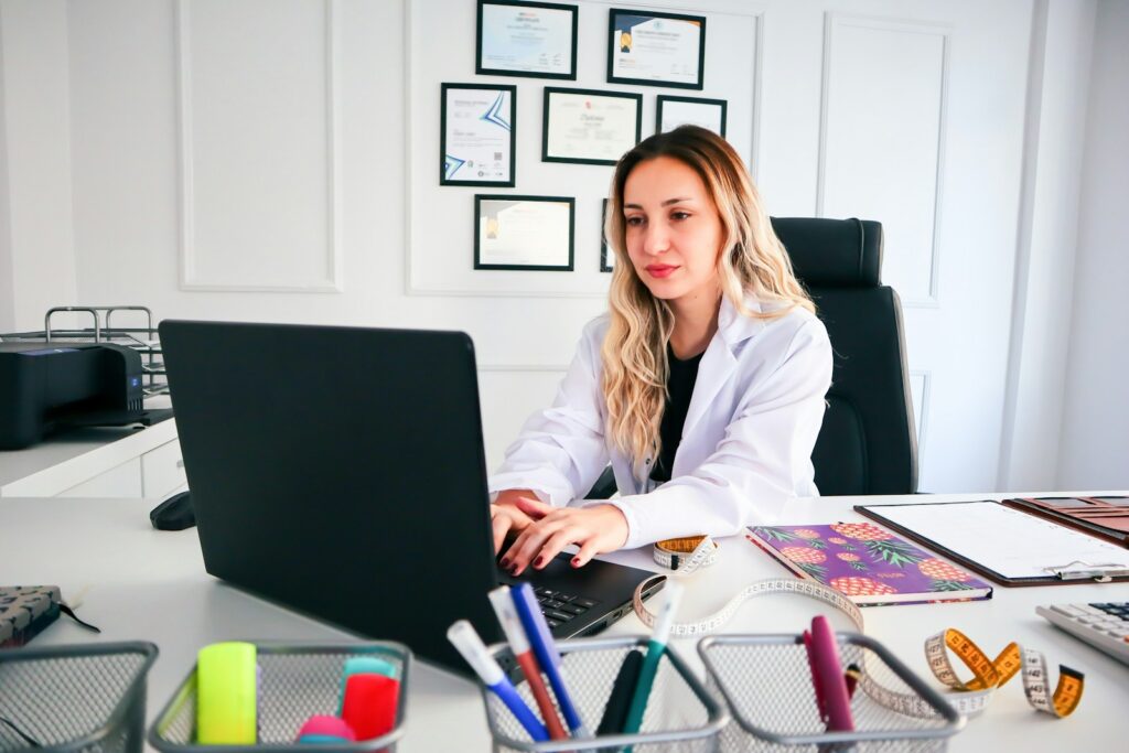 a woman sitting at a desk working on a laptop